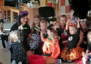 Dzieci bawią się i tańczą na balu Halloween.