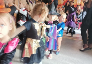 Dzieci bawią się i tańczą na balu Halloween.