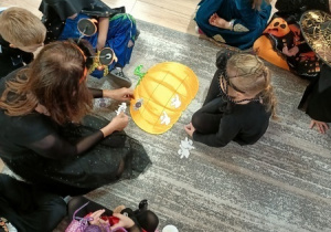 Dzieci bawią się i tańczą na balu Halloween.