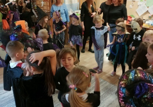 Dzieci bawią się i tańczą na balu Halloween.