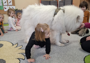 Dzieci przechodzą pod psem.