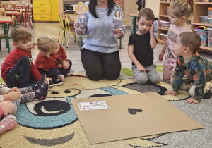 Pani demonstruje dzieciom złą i dobrą emotkę.