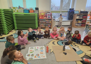 Pani demonstruje dzieciom złą i dobrą emotkę.