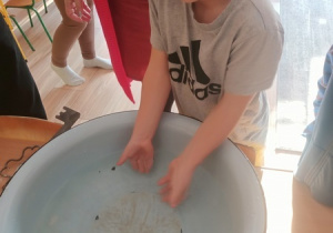 Dzieci czynią andrzejkowe wróżby.