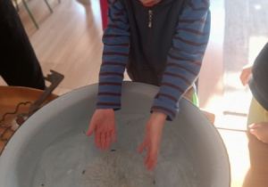 Dzieci czynią andrzejkowe wróżby.