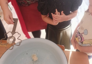 Dzieci czynią andrzejkowe wróżby.