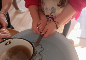 Dzieci czynią andrzejkowe wróżby.