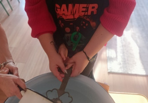 Dzieci czynią andrzejkowe wróżby.