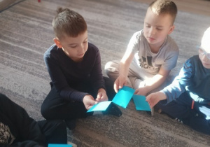 Dzieci czynią andrzejkowe wróżby.