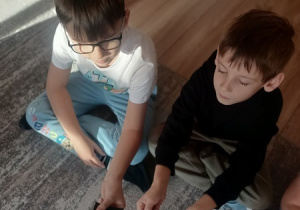 Dzieci czynią andrzejkowe wróżby.