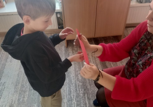 Dzieci czynią andrzejkowe wróżby.