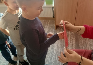 Dzieci czynią andrzejkowe wróżby.