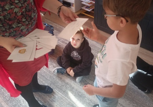 Dzieci czynią andrzejkowe wróżby.