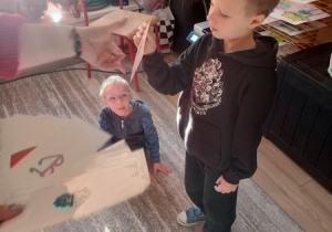 Dzieci czynią andrzejkowe wróżby.