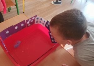 Dzieci czynią andrzejkowe wróżby.