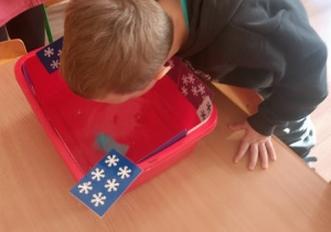 Dzieci czynią andrzejkowe wróżby.