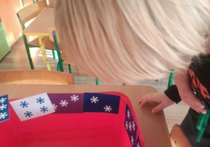 Dzieci czynią andrzejkowe wróżby.