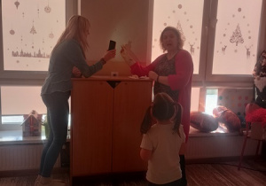 Dzieci czynią andrzejkowe wróżby.