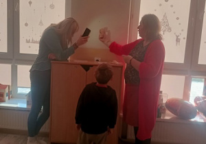 Dzieci czynią andrzejkowe wróżby.