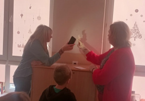 Dzieci czynią andrzejkowe wróżby.