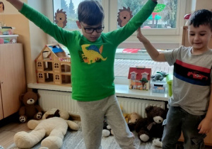 Dzieci bawią się z pluszowym misiem z okazji jego święta.