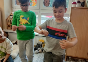 Dzieci bawią się z pluszowym misiem z okazji jego święta.