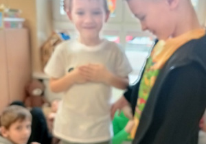 Dzieci bawią się z pluszowym misiem z okazji jego święta.