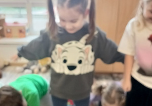 Dzieci bawią się z pluszowym misiem z okazji jego święta.