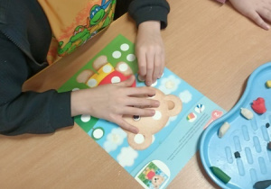 Dzieci bawią się z pluszowym misiem z okazji jego święta.