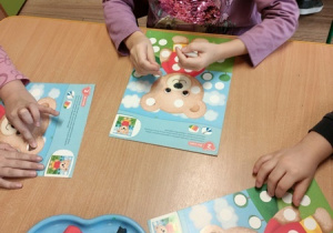 Dzieci bawią się z pluszowym misiem z okazji jego święta.