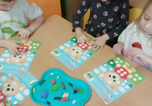 Dzieci bawią się z pluszowym misiem z okazji jego święta.