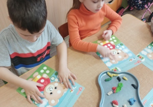 Dzieci bawią się z pluszowym misiem z okazji jego święta.