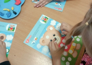 Dzieci bawią się z pluszowym misiem z okazji jego święta.