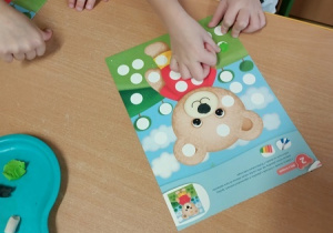 Dzieci bawią się z pluszowym misiem z okazji jego święta.