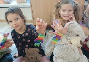 Dzieci bawią się z pluszowym misiem z okazji jego święta.