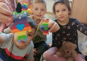 Dzieci bawią się z pluszowym misiem z okazji jego święta.