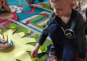 Jubilat rozkłada koraliki na słoneczku urodzinowym.