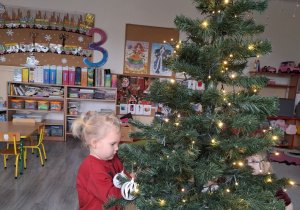 Dzieci ubierają choinkę.