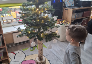 Dzieci ubierają choinkę.