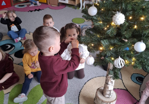 Dzieci ubierają choinkę.