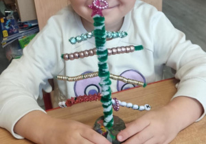 Dziecko dekoruje choineczkę.