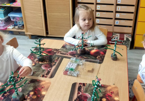 Dzieci dekorują choineczki.