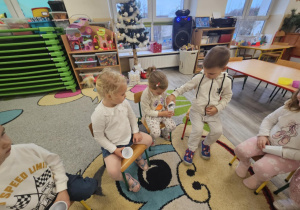 Dzieci przesypują śnieg sztuczny z kubeczka do kubeczka.