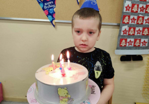 Jubilat zdmuchuje świeczki.