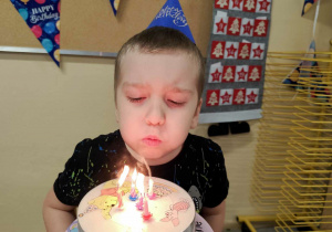 Jubilat zdmuchuje świeczki.