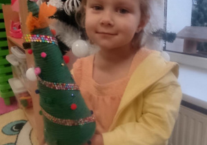 Dziewczynka z choinką własnoręcznie robioną.
