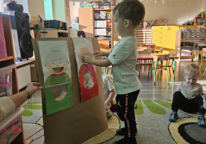 Dziecko wrzuca babeczkę do makiety babci lub dziadka.