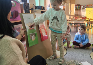 Dziecko wrzuca babeczkę do makiety babci lub dziadka.