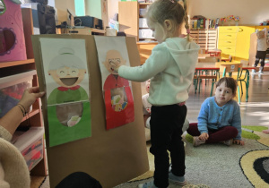 Dziecko wrzuca babeczkę do makiety babci lub dziadka.