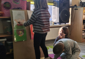 Dziecko wrzuca babeczkę do makiety babci lub dziadka.